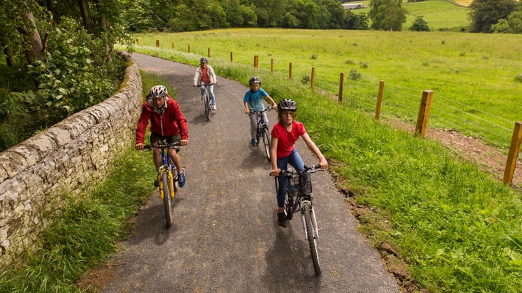 A family cycling on the Dragon Cycle Trail at Wallington, Northumberland